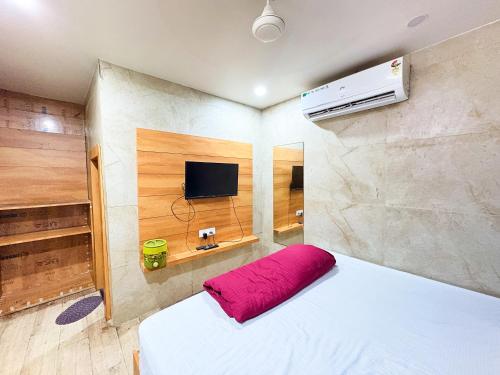 a bedroom with a white bed and a tv at Hotel Nenu-Mal ajmer AC OR NON AC Both Room in Ajmer