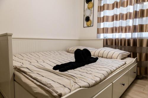 a unmade bed with a black object laying on it at Holiday House Valaliky in Valaliky