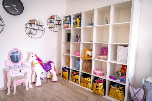a childs room with a white book shelf filled with toys at Holiday House Valaliky in Valaliky