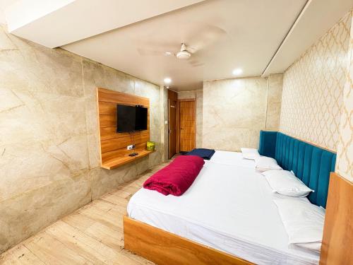 a bedroom with a large bed with a tv on the wall at Hotel Nenu-Mal ajmer AC OR NON AC Both Room in Ajmer