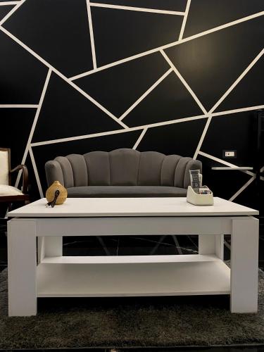a white coffee table in front of a black wall at Syràkousai Prestige in Syracuse