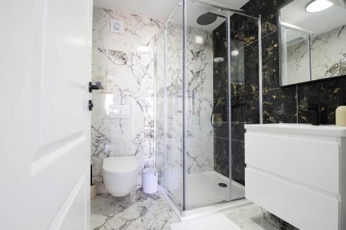 a bathroom with a glass shower and a toilet at Villa Romana in Bibinje