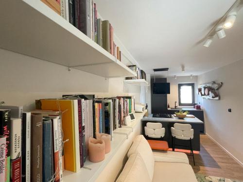 a living room with a row of books at Alpine Hideaway in a 1700's Borgata in Bussoleno