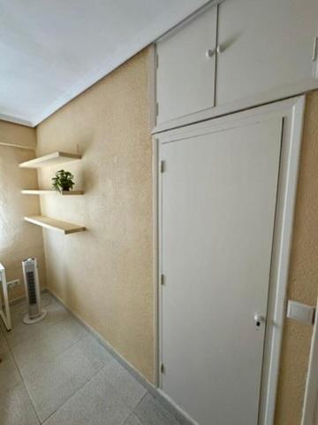 a kitchen with a wall with shelves and a door at 1st Line Beach Direct Access Private Parking in Valencia