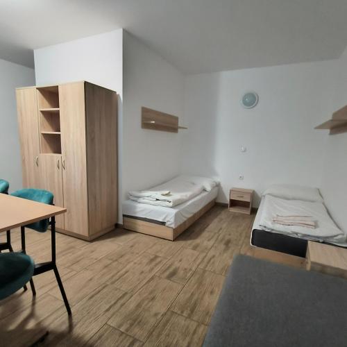 a room with two beds and a desk and a table at Rekreačné zariadenie Javorinka in Stará Turá