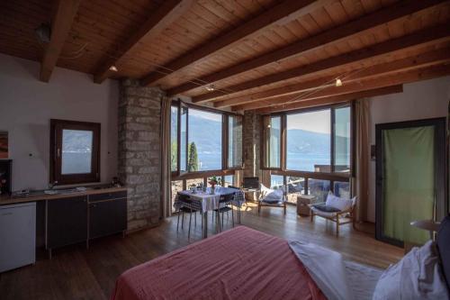 Un dormitorio con cocina y un salón con ventanas. en Apartments in Tignale - Gardasee 36094, en Olzano