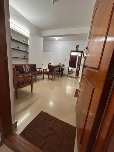 a living room with a couch and a table at Shivv's Leisure in Ooty