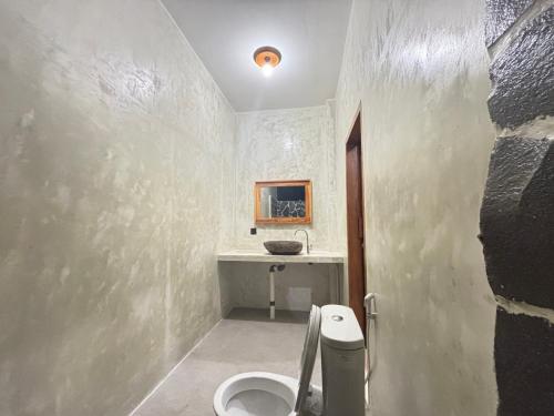 a bathroom with a toilet and a sink at Mengalung Bungalow in Kuta Lombok