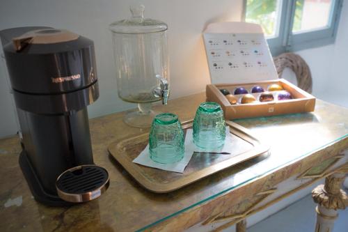a counter with a box of donuts and a coffee maker at Château Lestéous 