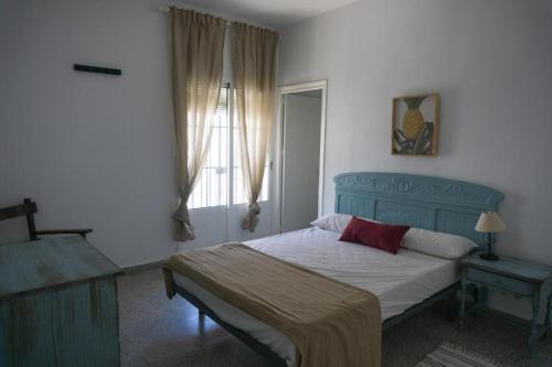 a bedroom with a blue bed and a window at Gran alojamiento a 1 metro de la playa con magnificas vistas in Chipiona