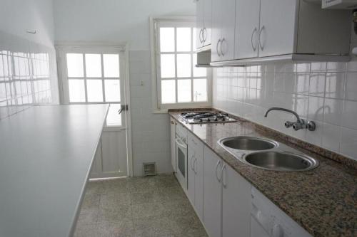 a white kitchen with a sink and a stove at Gran alojamiento a 1 metro de la playa con magnificas vistas in Chipiona