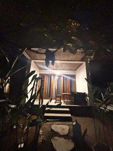 a room with a table and some stairs at night at Mengalung Bungalow in Kuta Lombok