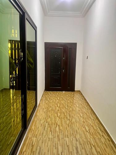 a hallway with a door and a wooden floor at Luxe on the lane in Kwedonu