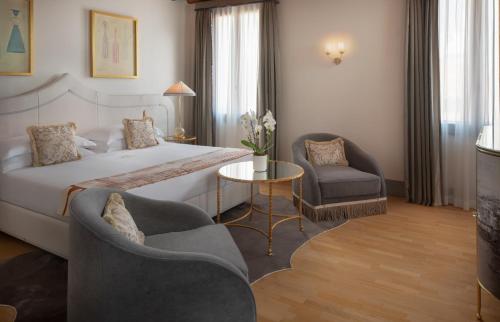 a hotel room with a bed and two chairs at Hotel Gabrielli Venezia - Starhotels Collezione in Venice