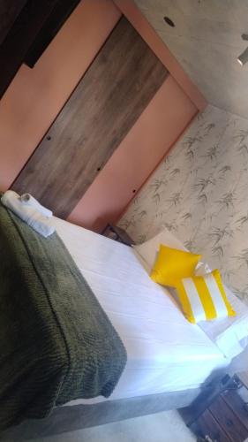 a bed with yellow pillows on it in a attic at Barranquilla Dreams in Puerto Colombia