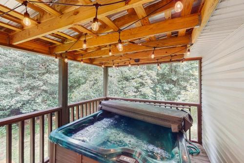 a hot tub on a screened in porch with lights at Laurel Creek in Helen