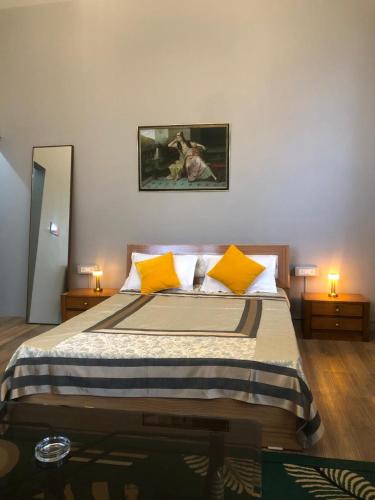 a bedroom with a large bed with yellow pillows at Beaumont Homestay 377 in Shillong