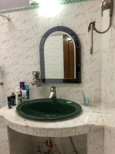 a bathroom with a green sink and a mirror at Beaumont Homestay 377 in Shillong