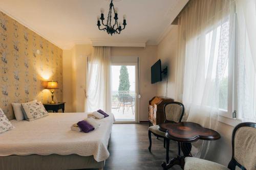 a bedroom with a bed and a table and a window at Hotel Villa Sevasti in Katerini