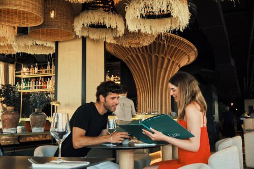 a man and a woman sitting at a table in a restaurant at ESTIMAR Marina Farnals in Puebla de Farnals