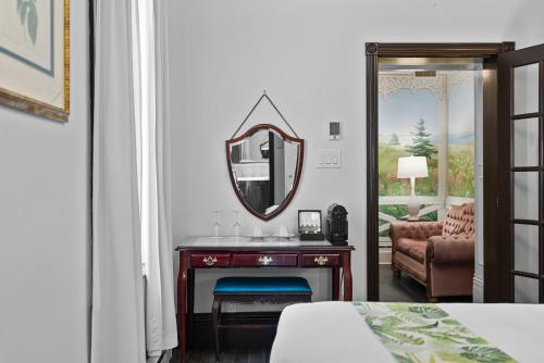 a bedroom with a mirror and a table with a chair at Le Clos Saint-Louis in Quebec City