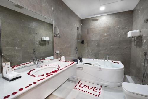 a bathroom with two sinks and a tub and a toilet at Dancenter Jeddah Near King Fahd's Fountain in Jeddah