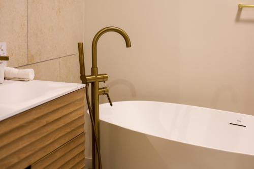 a bath tub with a brass faucet in a bathroom at Domaine Robert in Rognes