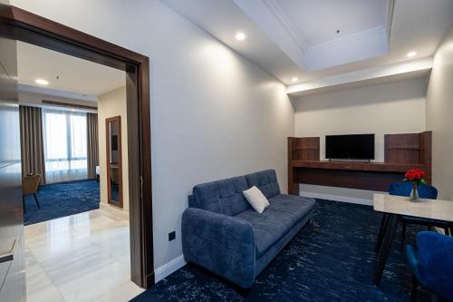 a living room with a couch and a tv at Dancenter Jeddah Near King Fahd's Fountain in Jeddah