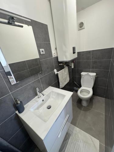 a bathroom with a white sink and a toilet at DIGITONE By GATES in Marignane