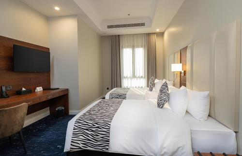 a hotel room with a bed and a television at Dancenter Jeddah Near King Fahd's Fountain in Jeddah