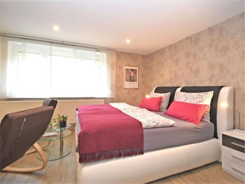 a bedroom with a large bed with red pillows at Ferienwohnung Christina in Friedrichroda in Friedrichroda
