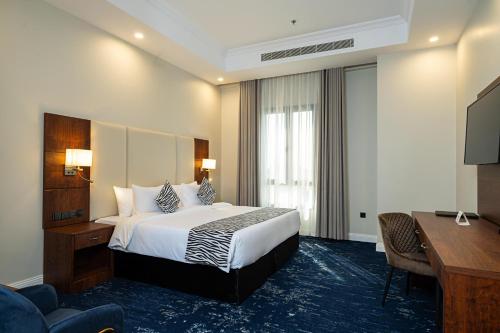 a hotel room with a bed and a desk at Dancenter Jeddah Near King Fahd's Fountain in Jeddah