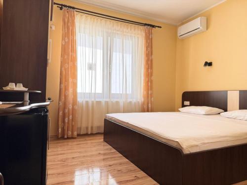 a bedroom with a large bed and a window at Casa Anamaria in Baile Felix