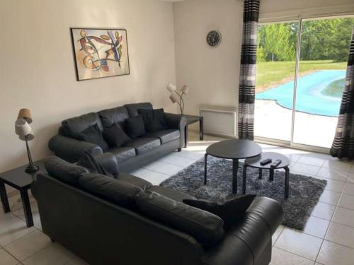 a living room with a couch and a table and a pool at Panoramic Poolside Villa in La Croix-Blanche