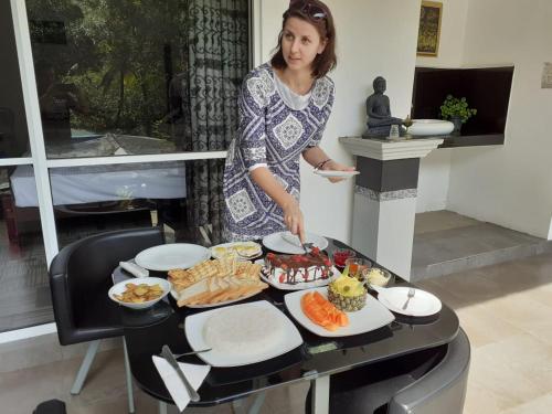 a woman standing in front of a table with food at Ella Rock Land in Ella