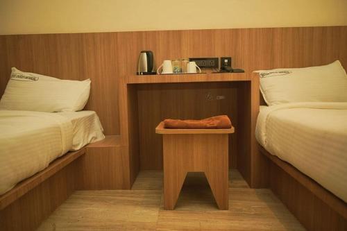 a hotel room with two beds and a table with a phone at Hotel Indian Imperial in Kumbakonam
