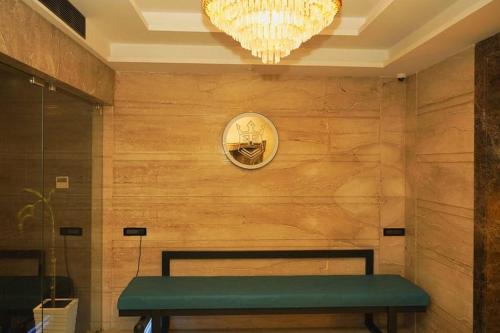 a room with a bench and a clock on a wall at Hotel Indian Imperial in Kumbakonam