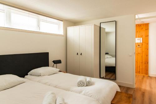 two beds in a bedroom with a mirror at Dutchen Park Weideduyn in Schoorl