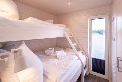 a bedroom with two bunk beds and a window at Hausboot Schatzkiste in Fehmarn