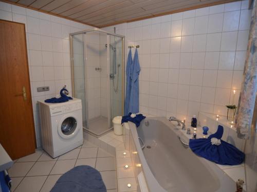 a bathroom with a tub and a washing machine at Schönes Ferienhaus mit großem Garten bei Stadlern in Stadlern