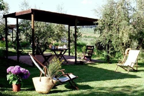- une table de pique-nique et des chaises sous un kiosque dans l'établissement Appartamento Rosso, à San Donato in Poggio