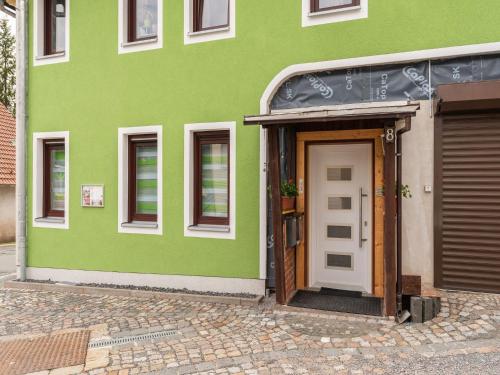 a green building with a door in front of it at Wohnung in Stützerbach nahe Skipiste in Stützerbach