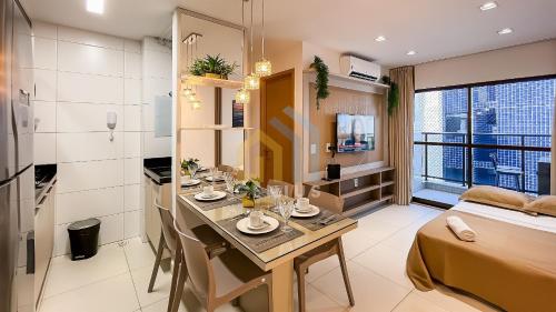 a room with a table and a bed and a kitchen at Buenos Ayres Cabo Branco Genius Flats in João Pessoa