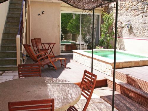 un patio avec une table et des chaises et une piscine dans l'établissement Holiday Home in Cazouls with Pool and Terrace, à Montagnac