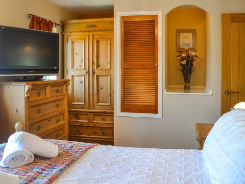 a bedroom with a bed with a television and a dresser at Rowan House in Beverley