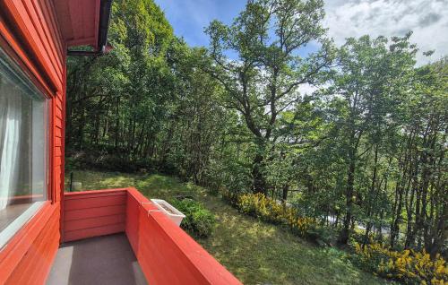 a balcony of a red house with a view of trees at Lovely Home In Masfjordnes With Wifi in Masfjorden
