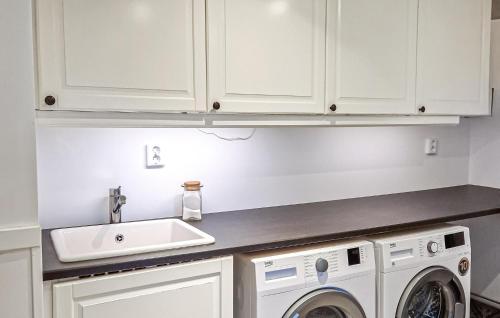a kitchen with a sink and a washing machine at Stunning Home In Asarum With Wifi in Asarum