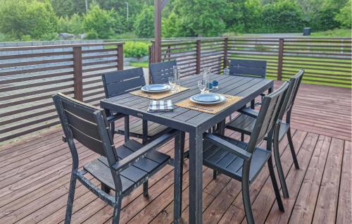 a wooden table with four chairs on a deck at Stunning Home In Asarum With Wifi in Asarum