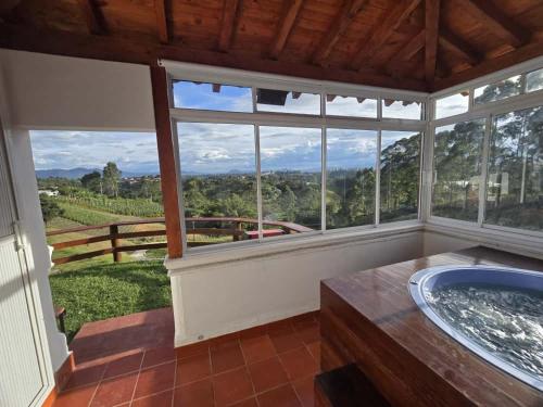 a bathroom with a tub and a large window at Luxurious country cabin, BBQ, Jacuzzi, TV, WiFi in Marinilla