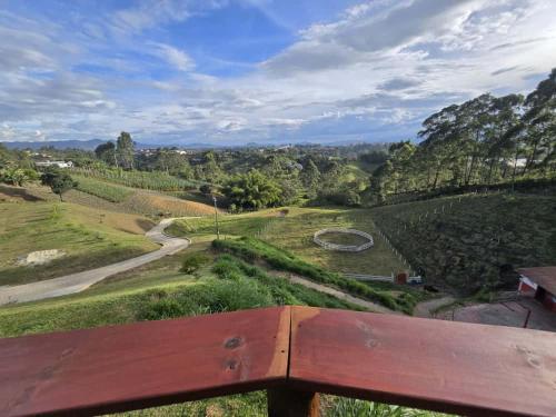 a view of a vineyard from a wooden bench at Luxurious country cabin, BBQ, Jacuzzi, TV, WiFi in Marinilla